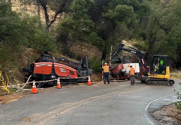 Ditch Witch directional drilling equipment and crew operating on a road