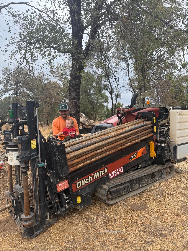 Ditch Witch JT9 directional drill with owner Wyatt Wass and child